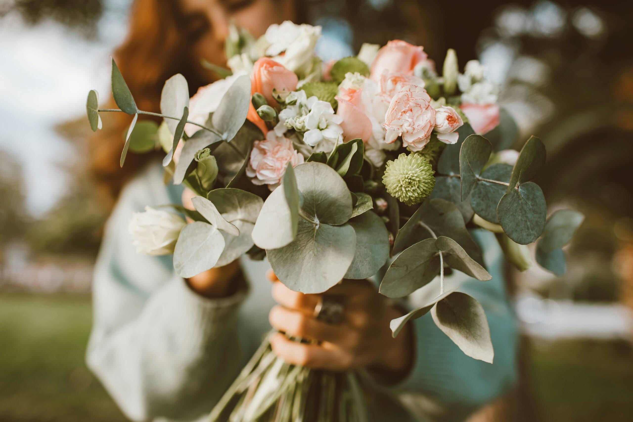 A bouquet of fresh organic roses, chamomile, and calendula against a soft pastel background, showcasing their natural beauty.