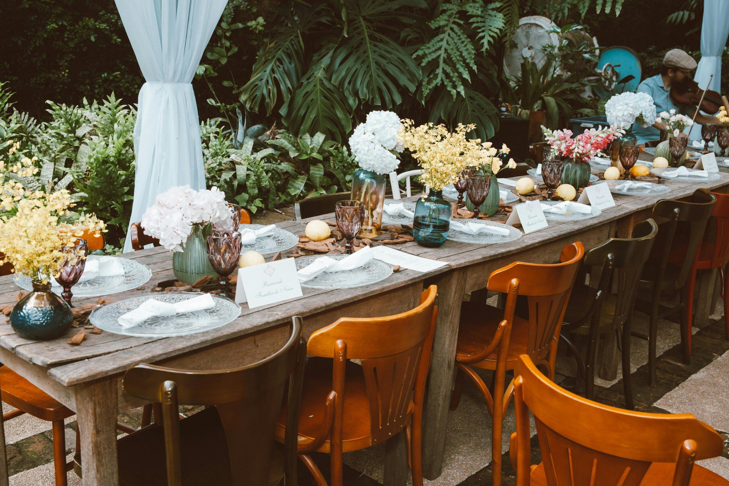 A glass jar filled with yellow chamomile flowers soaked in water, set against a rustic wooden table.